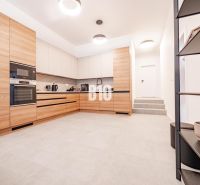 A kitchen in a family house with wooden decor and white walls.