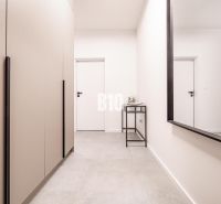 Hallway with a mirror and white walls in a family house.