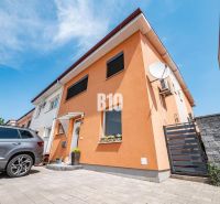 A family house in Nitra with an orange facade and a car in the yard.