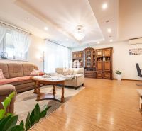 Interior of a family house with a living room, light curtains, and a floor with a wooden decor.