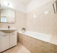 A bathroom in a 2-room apartment with a bathtub and a sink, tiled.