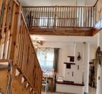 Interior of a family house with a staircase and a fireplace, floor with wooden decor.