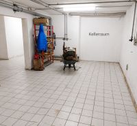 Basement with tiles, a shelf, and a coat in a family house.