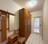 A hallway in a 3-room apartment with wooden decor and tiled flooring.