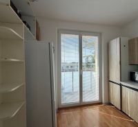 A kitchen in a 3-room apartment with a wooden decor floor and built-in cabinets.