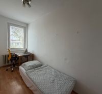 A room in a 3-room apartment with a bed, a table, and a floor with a wooden decor.