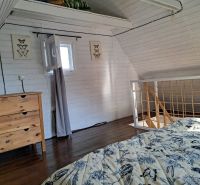 Interior of a cabin with a bed and a cabinet, floor with wooden decor.