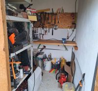 Tools and equipment in the utility room of the cabin with a wooden decor floor.