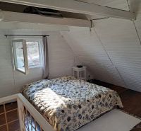 Bedroom with wood-patterned flooring and a bed in a cabin.