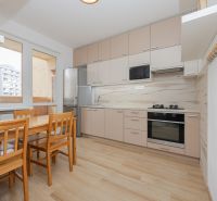 A kitchen in a 3-room apartment with a wooden decor and a dining area, bright and spacious.