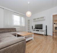 Living room with a corner sofa, TV, and wooden decor flooring in a 3-room apartment.