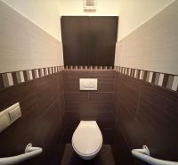 A toilet with patterned tiles in a 3-room apartment.