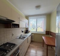 A kitchen in a 3-room apartment with a wood-patterned floor and a dining table.