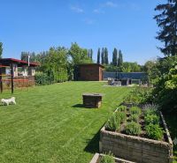 Garden in Kamenný mlyn, Trnava with a green lawn and raised beds.
