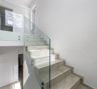 Glass railing with staircase in a family house, bright room, simple design.
