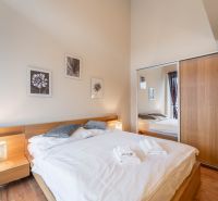 Bedroom with a bed and wood-patterned flooring in a holiday apartment.