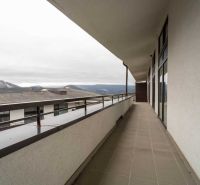 The balcony of the recreational apartment in Donovaly offers a view of the surrounding mountains and rooftops.