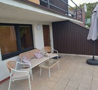 Terrace of the Cottage in Kaluža with seating and a sunshade.