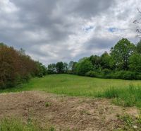 Plots - housing on Hlavná Street in Tovarnianska Polianka, surrounded by greenery and trees.