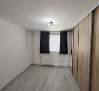 A room in a 3-room apartment with a wooden decor floor and a built-in wardrobe.