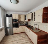 A kitchen in a 3-room apartment with a wooden decor floor and appliances.