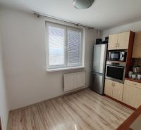 A kitchen in a 3-room apartment with a window and a floor with a wooden decor.