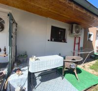 Terrace of a family house in Divín with a canopy, table, and rattan chair.
