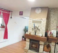 Living room in a family house with a fireplace and decorative furniture, floor with wooden decor.