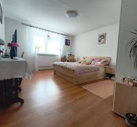 A bedroom in a family house with a bed and a wooden decor floor.