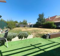 The garden of a family house in Divín with a lawn and a terrace for sitting.