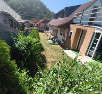 Family houses in Divín surrounded by greenery and blue skies.