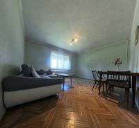 Living room in a family house with a sofa, table, and wooden decor flooring.