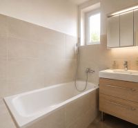A bathroom in a family house with a bathtub, a sink, and a cabinet in a wooden decor.