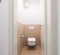 A bathroom with tiles in a 2-room apartment, neutral color palette.