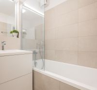 A bathroom with a bathtub and a sink in a 2-room apartment, bright tiles.