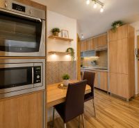 A kitchen in a 3-room apartment with a wooden floor decor and built-in appliances.