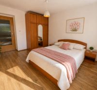 A bedroom in a 3-room apartment with a wooden decor floor and pastel elements.