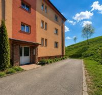 Apartment building in Istebné with green surroundings and a blue sky, ideal for a 3-room apartment.