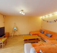Living room in a family house with an orange sofa, floor with wooden decor.