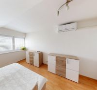 Bright bedroom with a dresser and wood-patterned flooring in a family house.