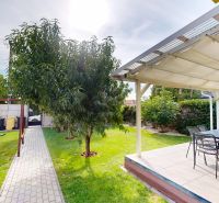 A garden with seating and swings in a family house in Oľdza.