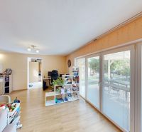 Living room in a family house with large windows and a wooden decor floor.