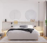 A bedroom in a family house with a bed, a plant, and a wooden decor floor.