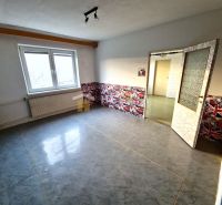 A room in a family house with a decorated wall and a large window, wooden decor flooring.