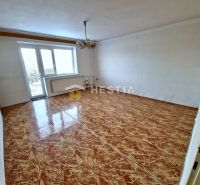 A room in a family house with a varnished floor, white walls, and a chandelier.