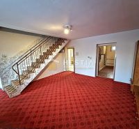 A staircase with a carpet and open doors in a family house.