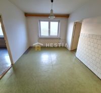 A spacious room with a window, tiles on the wall, and a floor in a family house.
