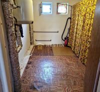 Storage space in a family house with a boiler and a floor with a geometric pattern.