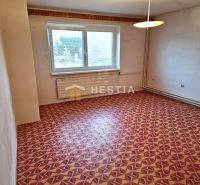 A room in a family house with a colorful geometric carpet and white walls.