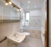 A bathroom with a bathtub, sink, and window in a 3-room apartment.